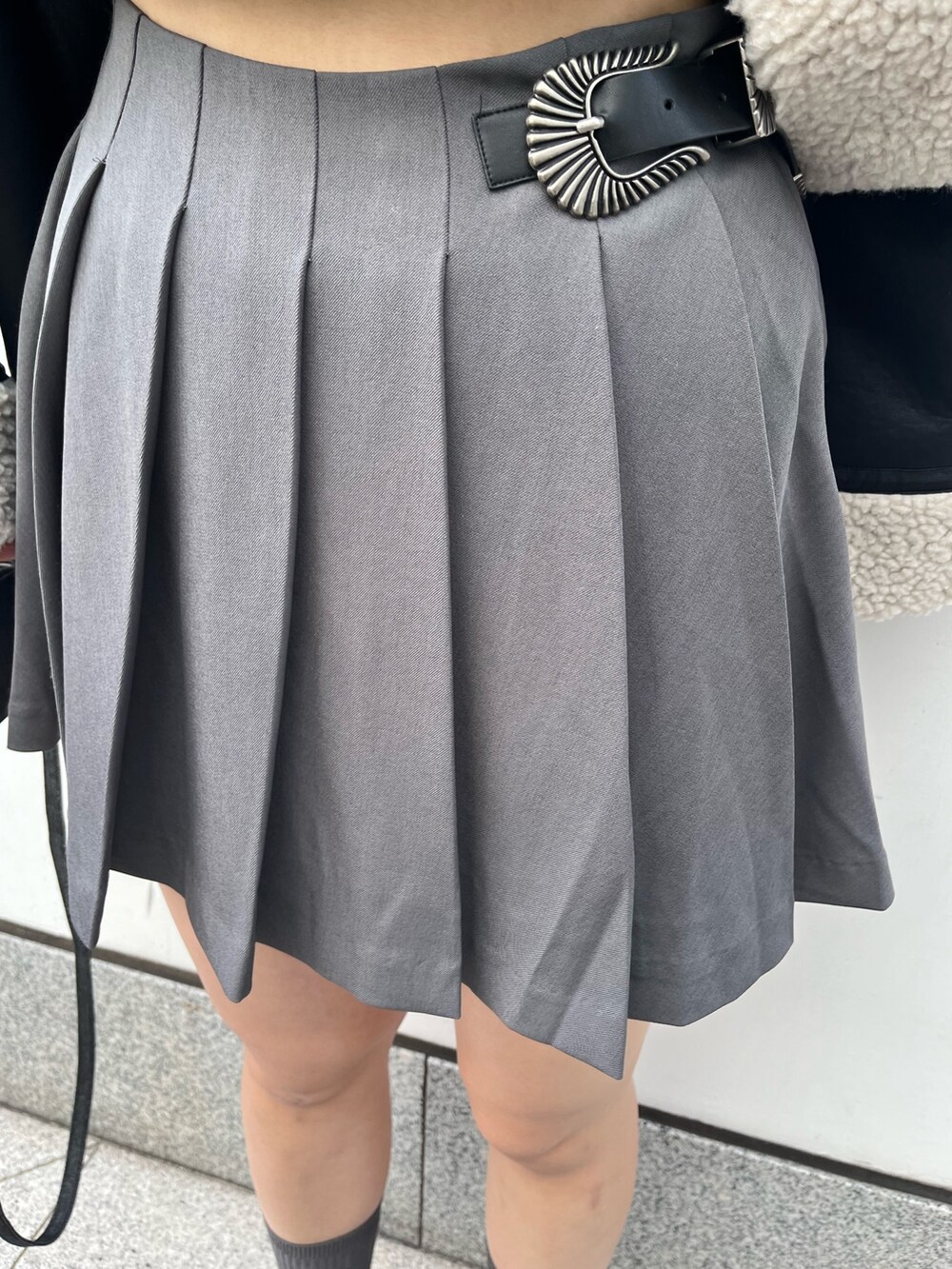 ブルー系のスウェット、グレー系のスカート、ブラック系のハンドバッグを着用したレディースの冬コーディネートの6枚目の写真