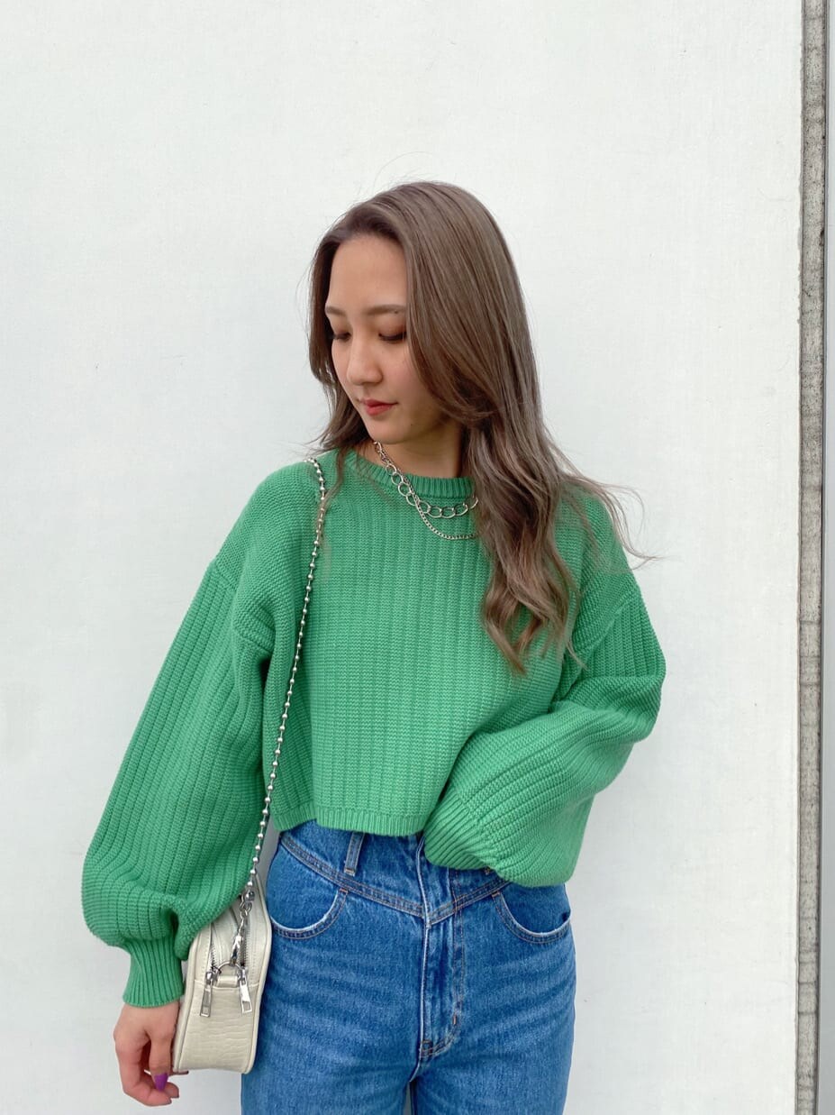 ブラック系のブーツ、ホワイト系のショルダーバッグ、グリーン系のニット/セーターを着用したレディースの冬コーディネートの3枚目の写真