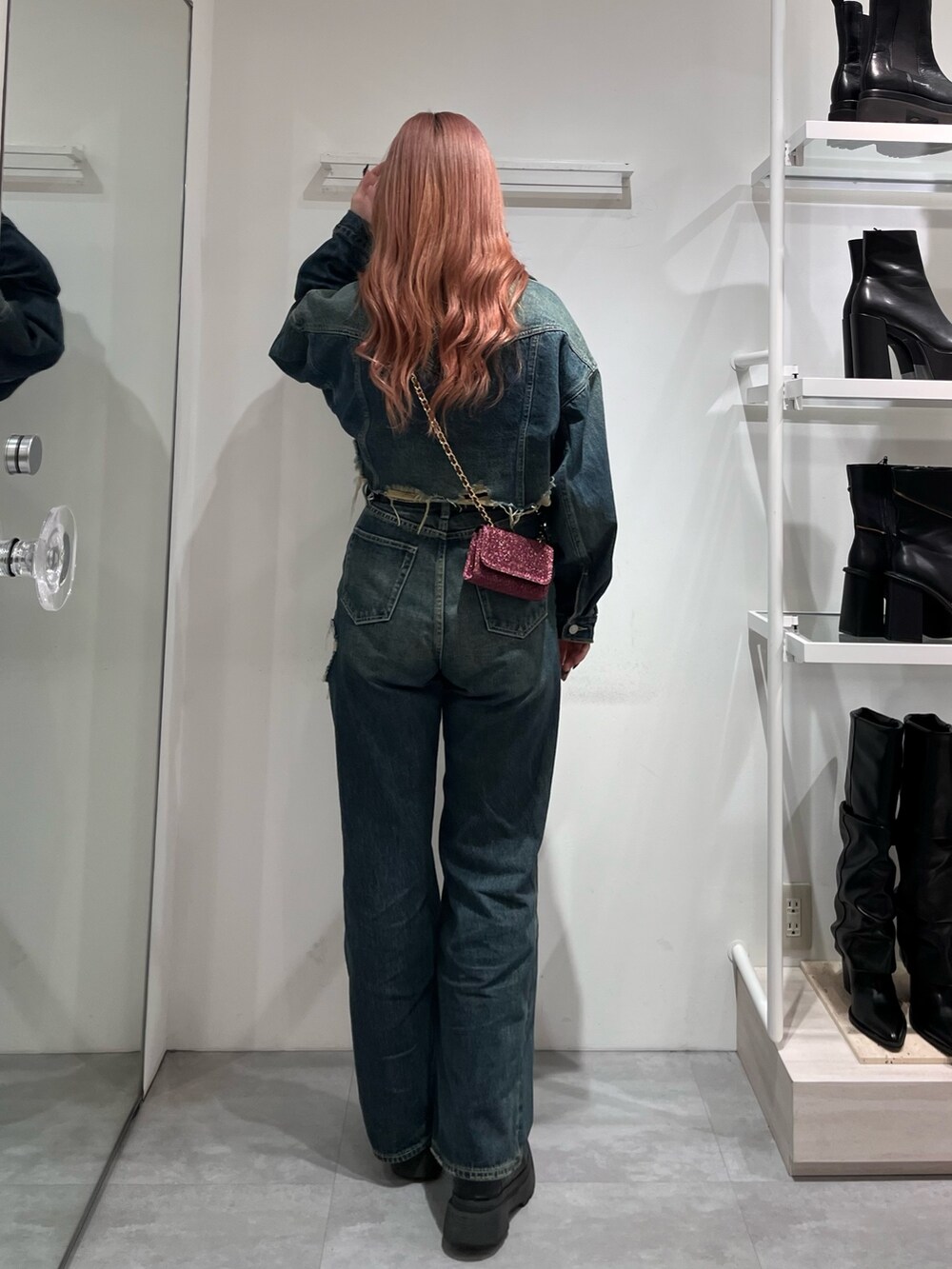 ブルー系のデニムジャケット、グレー系のニット/セーター、ブルー系のデニムパンツを着用したレディースの冬コーディネートの2枚目の写真