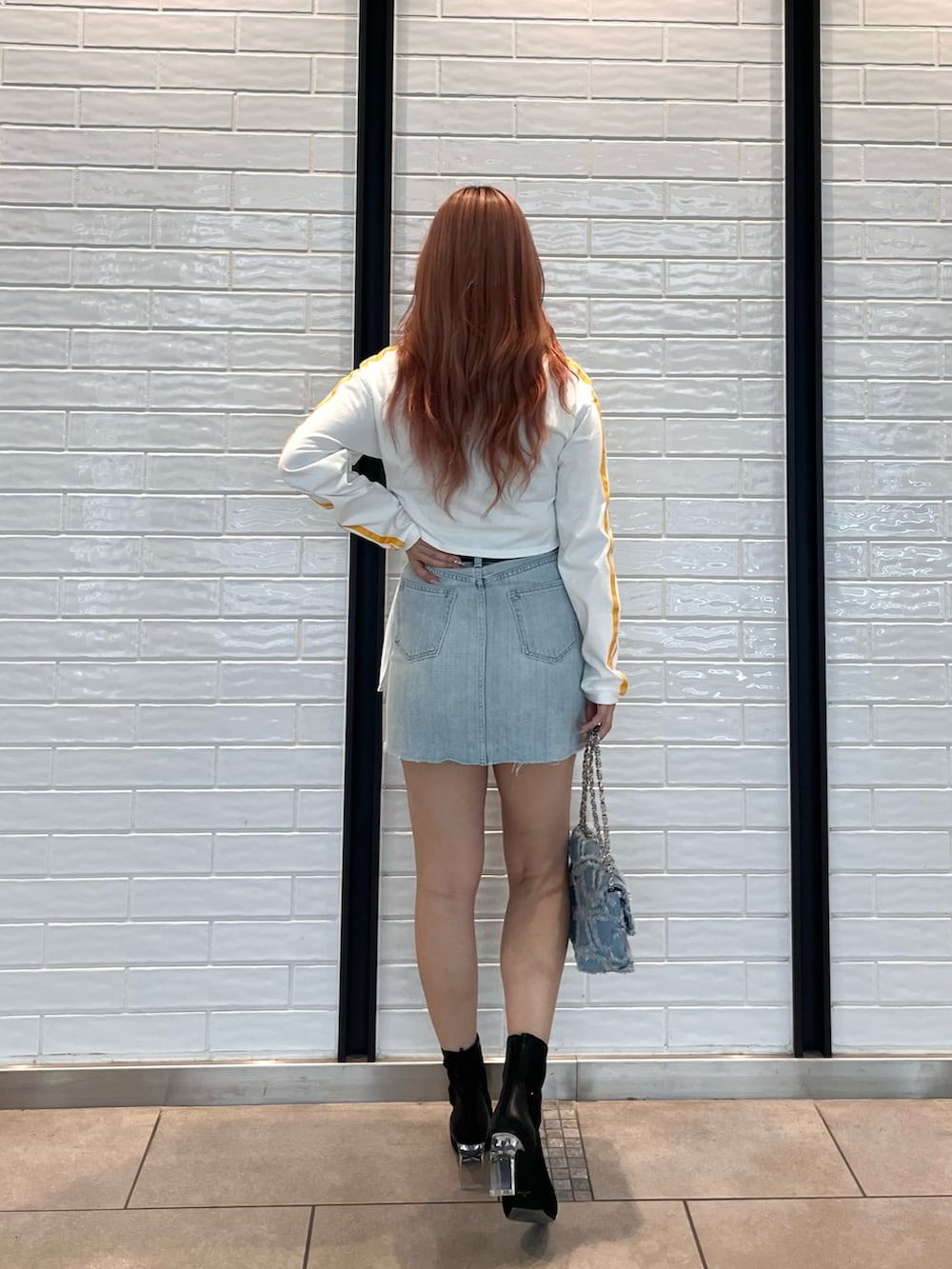 ホワイト系のTシャツ/カットソー、ブルー系のデニムスカート、ブルー系のショルダーバッグを着用したレディースの春コーディネートの2枚目の写真