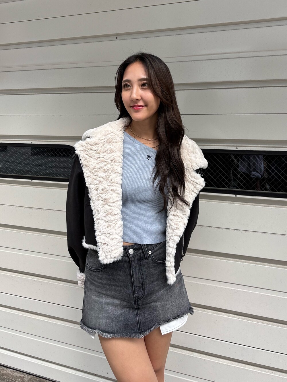 ブラック系のブルゾン、グレー系のニット/セーター、ブラック系のデニムスカートを着用したレディースの冬コーディネートの4枚目の写真