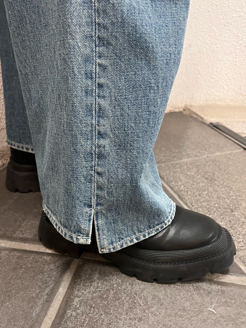 ブルー系のデニムパンツ、ブラック系のハンドバッグ、ブラック系のブーツを着用したレディースの冬コーディネートの8枚目の写真