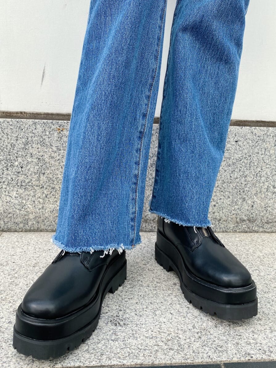 ブラック系のブーツ、ホワイト系のショルダーバッグ、グリーン系のニット/セーターを着用したレディースの冬コーディネートの7枚目の写真