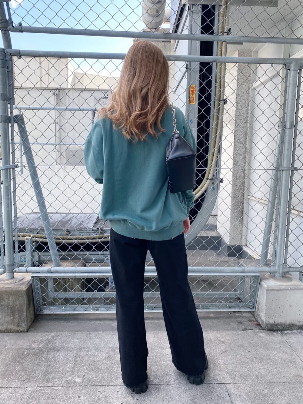 ブラック系のブーツ、ブラック系のショルダーバッグ、グリーン系のスウェットを着用したレディースの秋コーディネートの2枚目の写真
