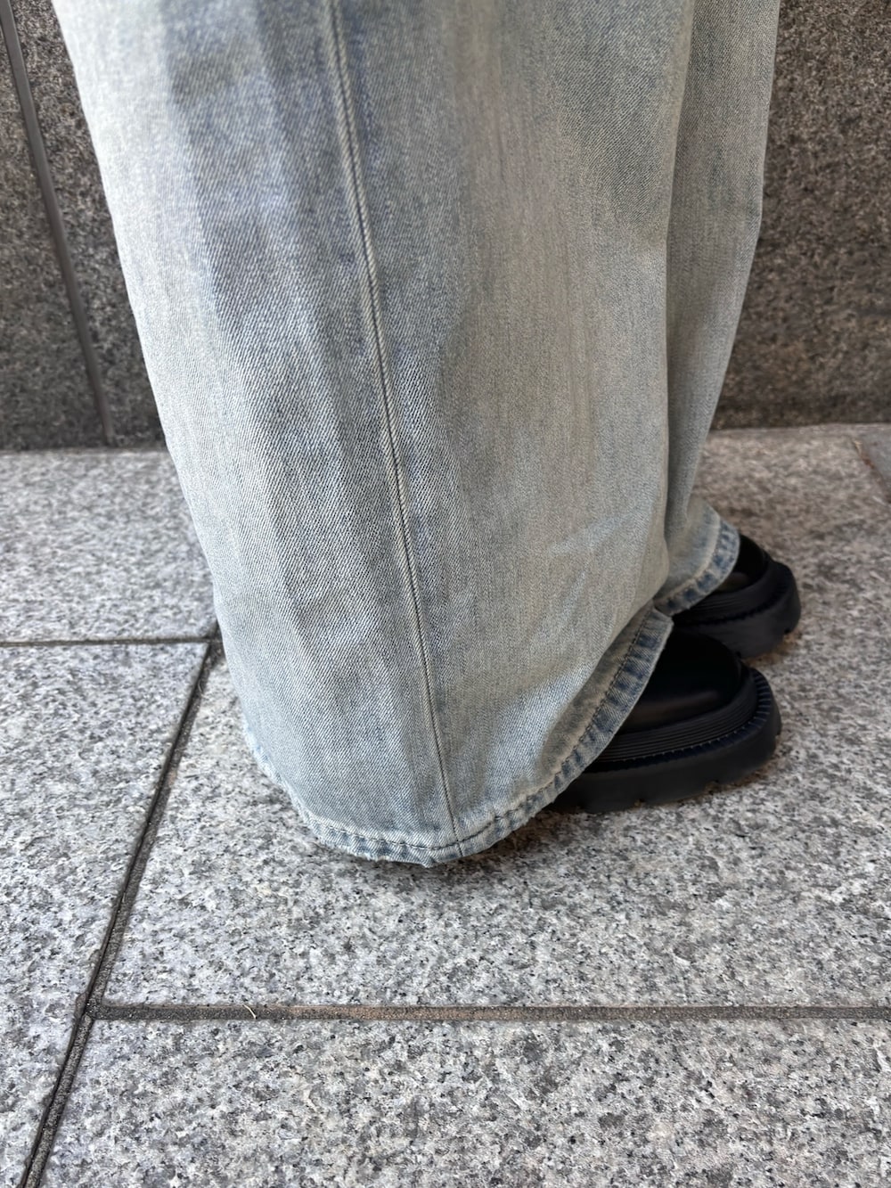 ブラック系のニット/セーター、ブラック系のキャミソール、ブルー系のデニムパンツを着用したレディースの春コーディネートの5枚目の写真