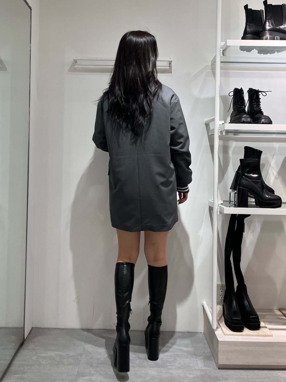 グレー系のテーラードジャケット、ブラック系のTシャツ/カットソー、ブラック系のブーツを着用したレディースの秋コーディネートの2枚目の写真