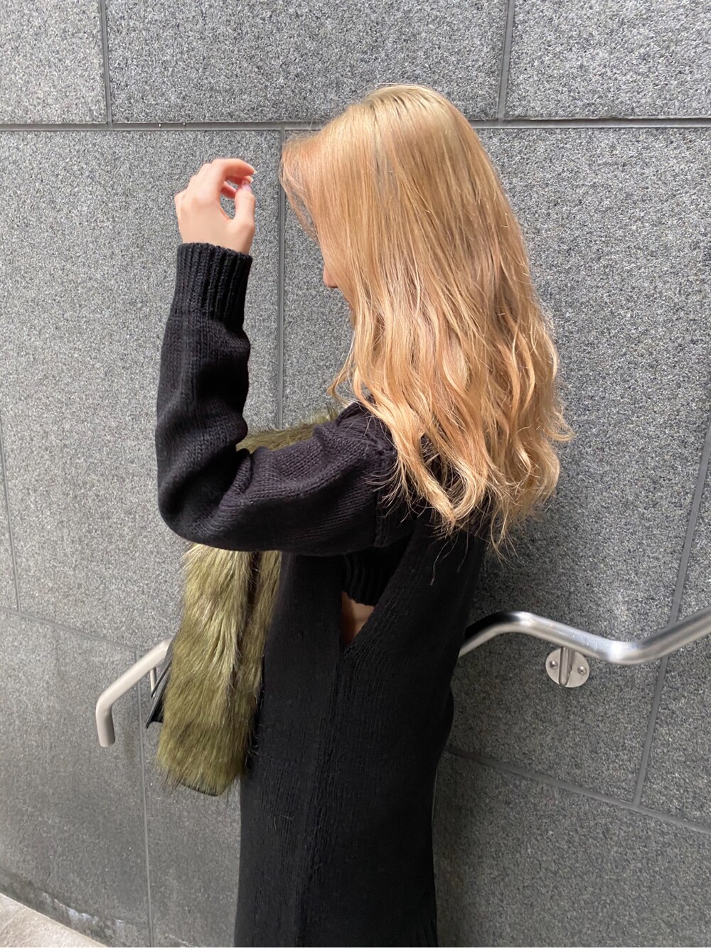 ブラック系のハンドバッグ、ブラック系のワンピースを着用したレディースの冬コーディネートの3枚目の写真