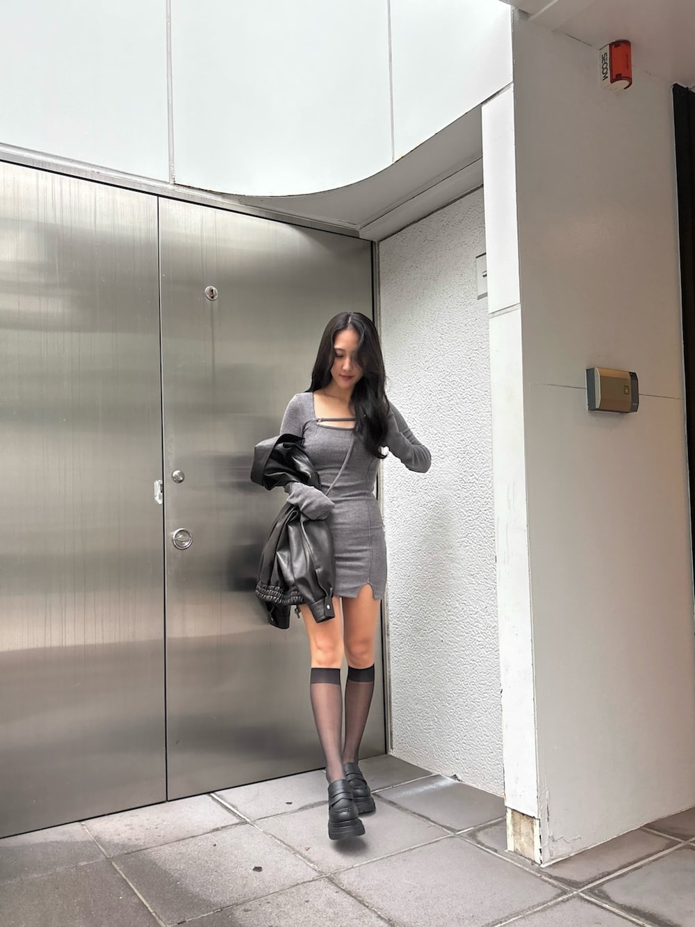 ブラウン系のブルゾン、ブラック系のローファー、グレー系のワンピースを着用したレディースの秋コーディネートの5枚目の写真