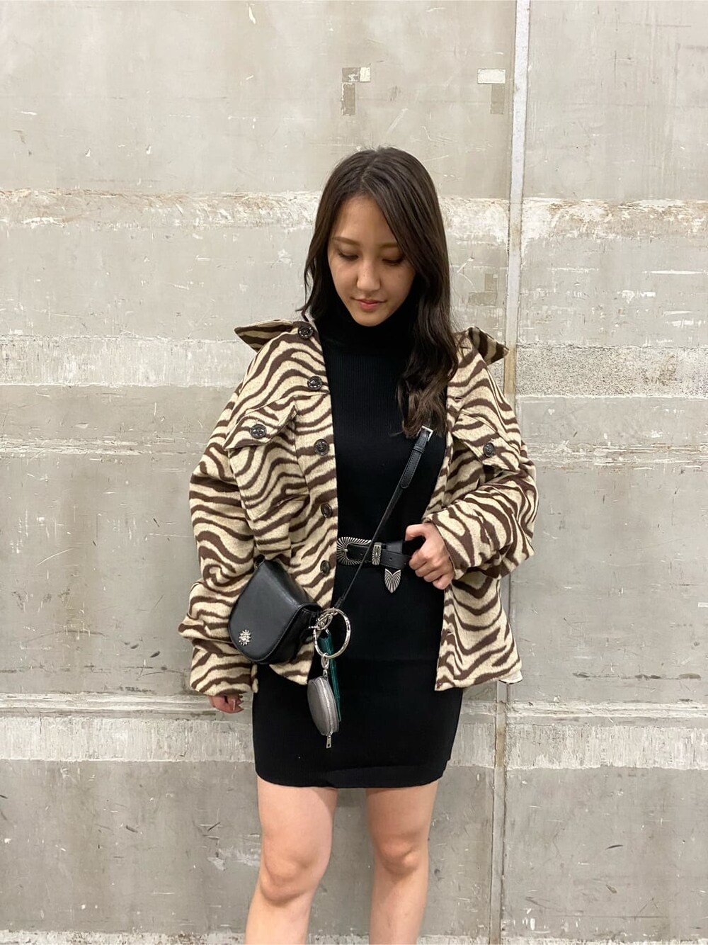 ブラック系のワンピース、ブラック系のショルダーバッグ、ブラック系のブーツを着用したレディースの秋コーディネートの3枚目の写真