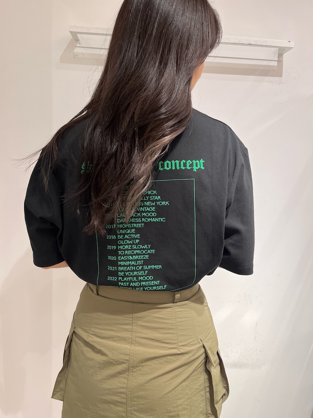 ブラック系のTシャツ/カットソー、グリーン系のスカート、ブラック系のブーツを着用したレディースの夏コーディネートの4枚目の写真