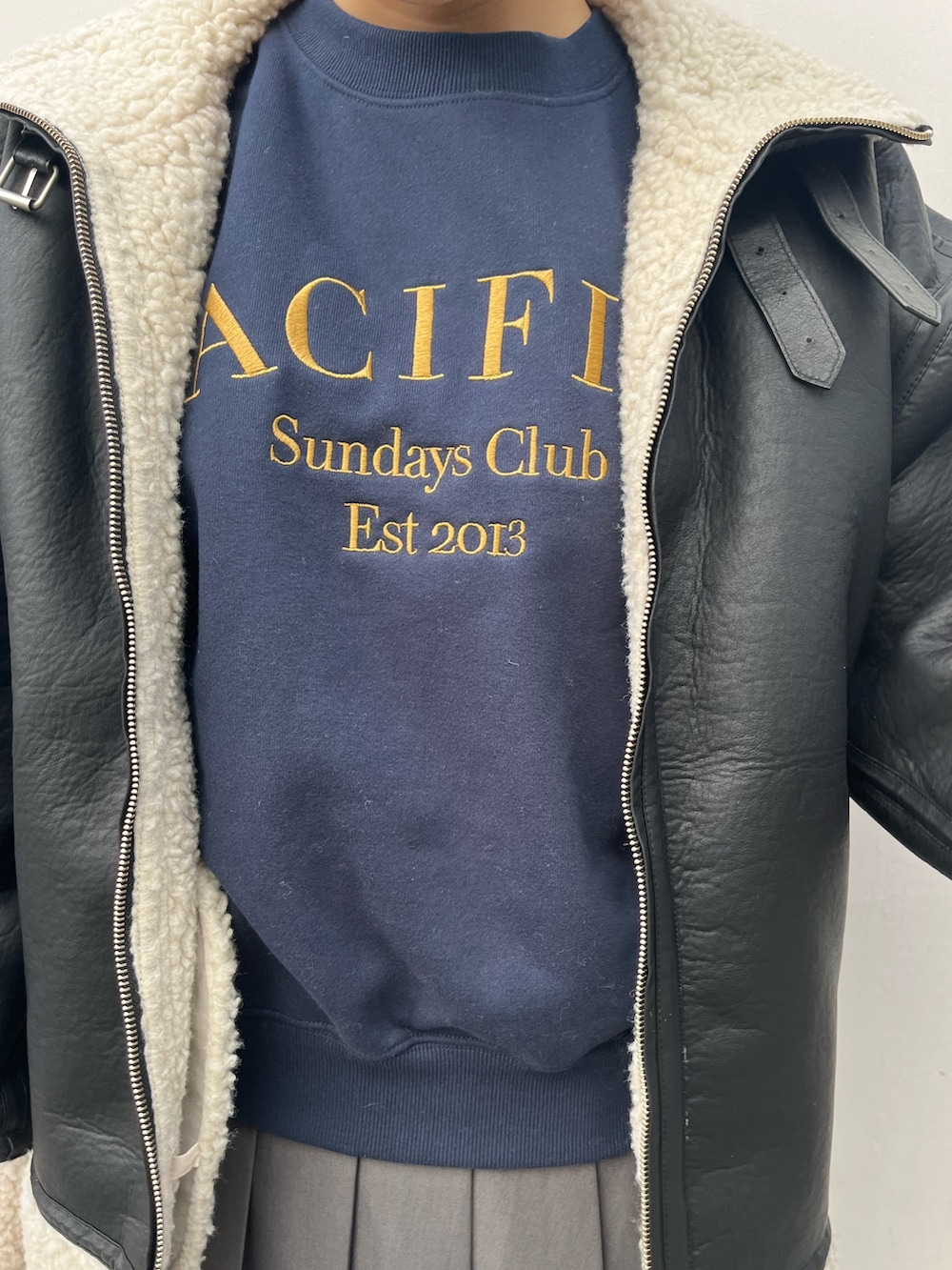 ブルー系のスウェット、グレー系のスカート、ブラック系のハンドバッグを着用したレディースの冬コーディネートの5枚目の写真