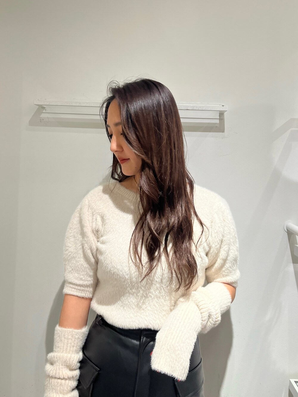 ホワイト系のニット/セーター、ブラック系のスカート、ブラック系のショルダーバッグを着用したレディースの冬コーディネートの2枚目の写真