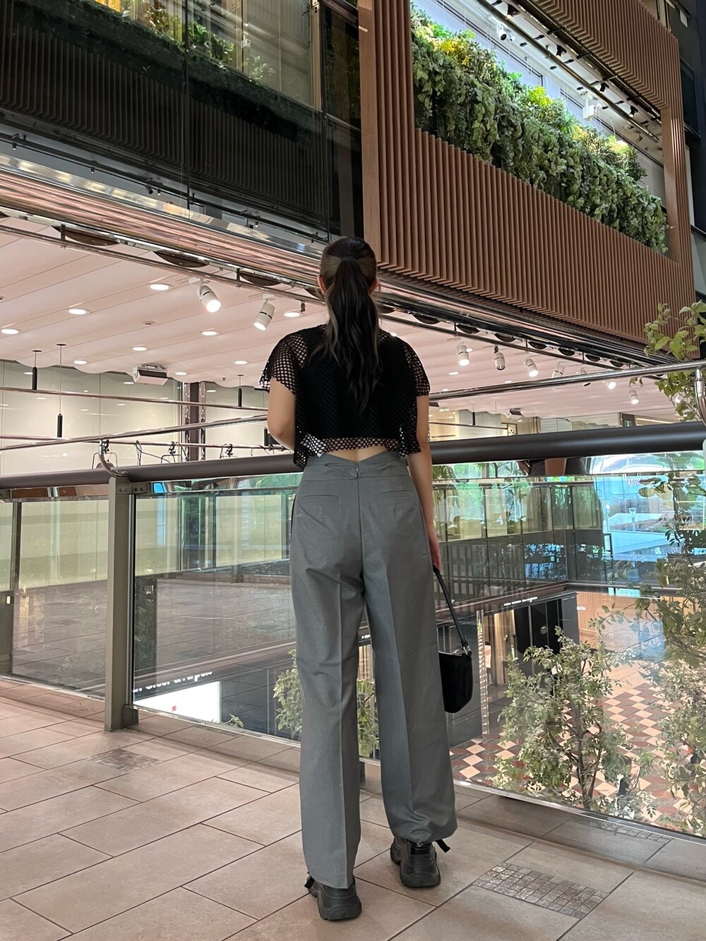 ブラック系のTシャツ/カットソー、グレー系のその他パンツ、ブラック系のハンドバッグを着用したレディースの夏コーディネートの2枚目の写真