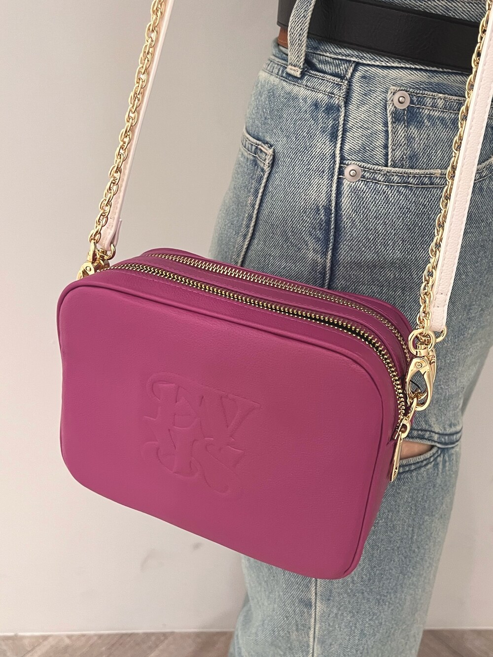 ブルー系のデニムパンツ、ブラック系のニット/セーター、パープル系のショルダーバッグを着用したレディースの春コーディネートの7枚目の写真