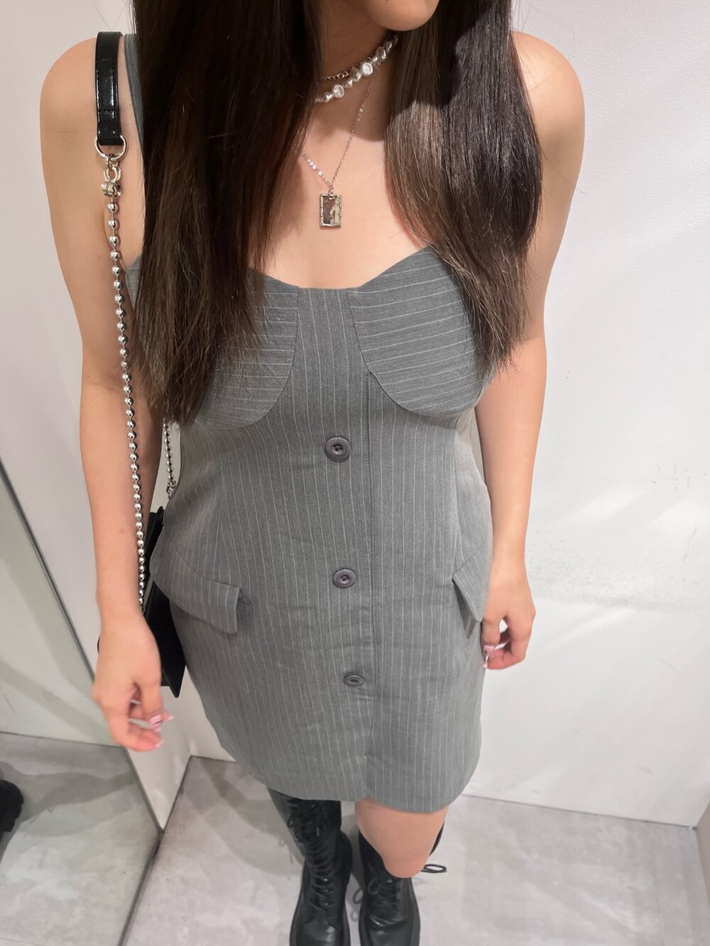 グレー系のワンピース、ブラック系のブーツ、ブラック系のショルダーバッグを着用したレディースの夏コーディネートの2枚目の写真