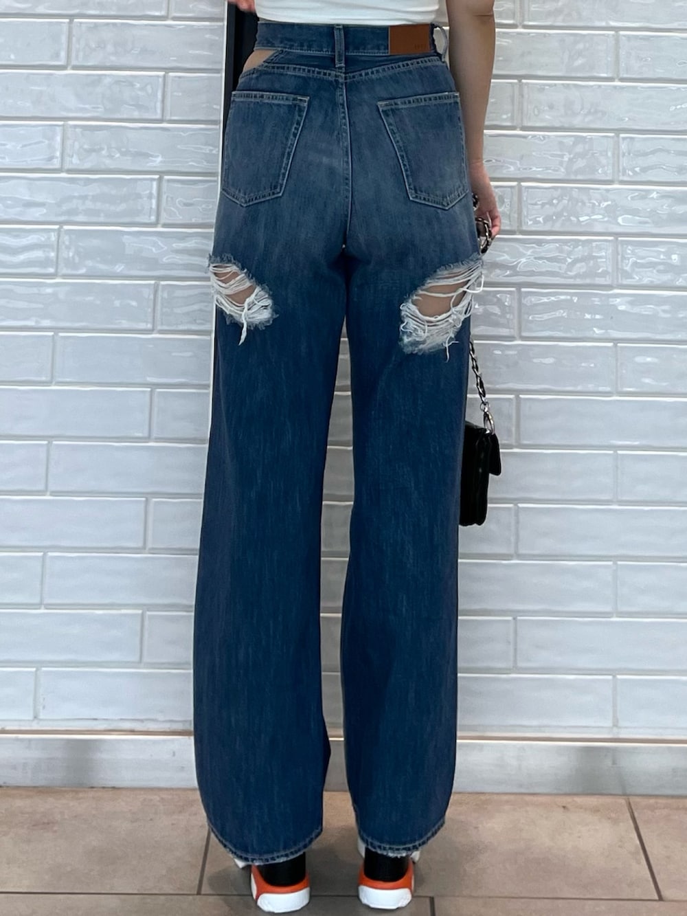 ホワイト系のTシャツ/カットソー、ブラック系のサンダル、ブラック系のショルダーバッグを着用したレディースの夏コーディネートの6枚目の写真