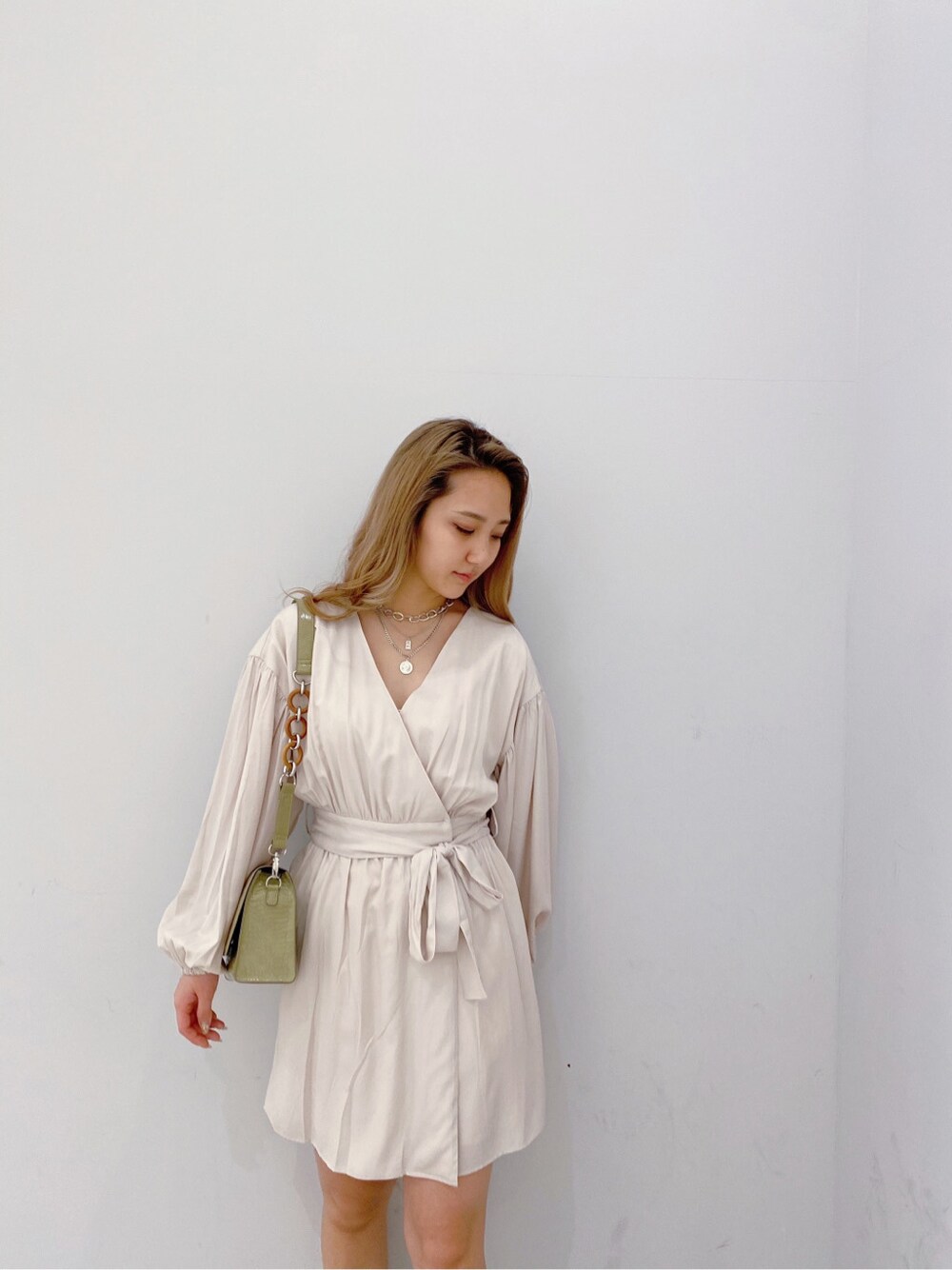 ベージュ系のブーツ、ホワイト系のワンピース、シルバー系のネックレスを着用したレディースの冬コーディネートの2枚目の写真