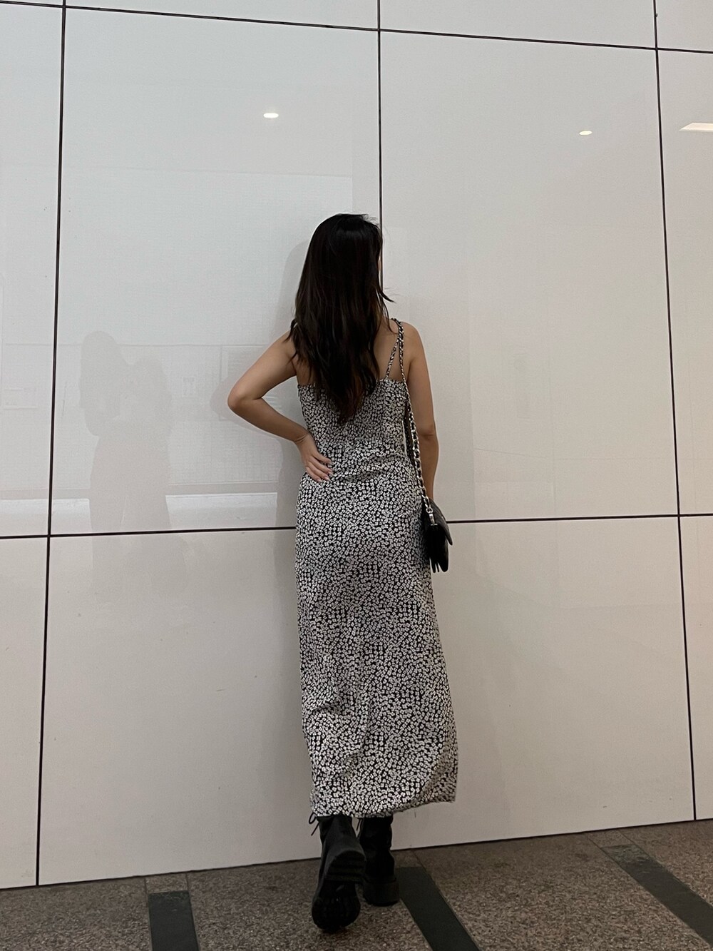 ブラック系のブーツ、ブラック系のワンピース、ブラック系のショルダーバッグを着用したレディースの春コーディネートの2枚目の写真