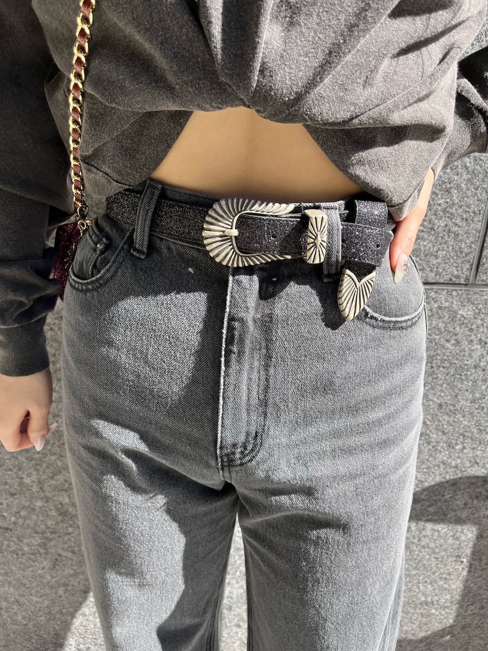 グレー系のTシャツ/カットソー、ブラック系のデニムパンツ、ピンク系のショルダーバッグを着用したレディースの冬コーディネートの7枚目の写真