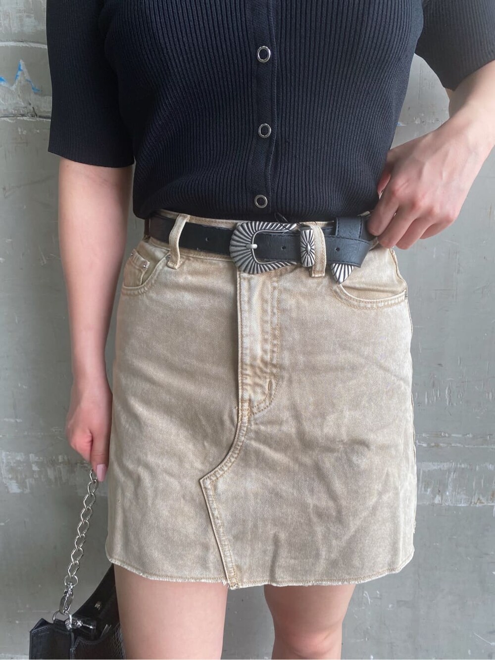 ベージュ系のデニムスカート、ブラック系のサンダル、ブラック系のTシャツ/カットソーを着用したレディースの夏コーディネートの4枚目の写真