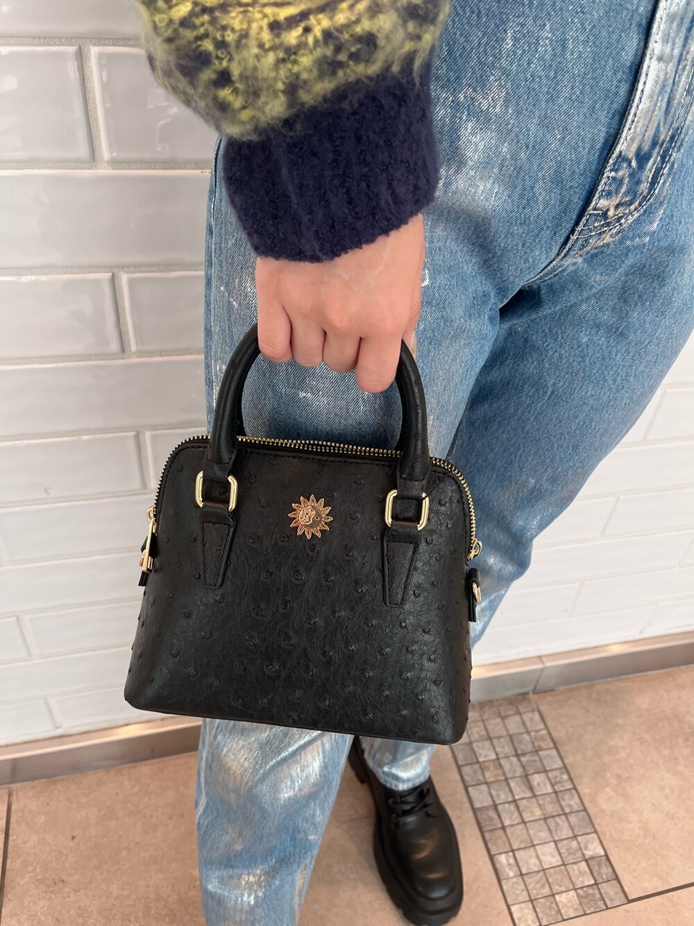 ブルー系のカーディガン/ボレロ、ブルー系のデニムパンツ、ブラック系のショルダーバッグを着用したレディースの秋コーディネートの6枚目の写真