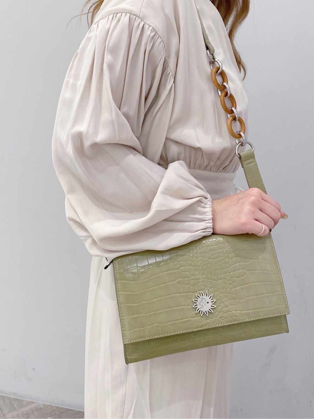 ベージュ系のブーツ、ホワイト系のワンピース、シルバー系のネックレスを着用したレディースの冬コーディネートの4枚目の写真