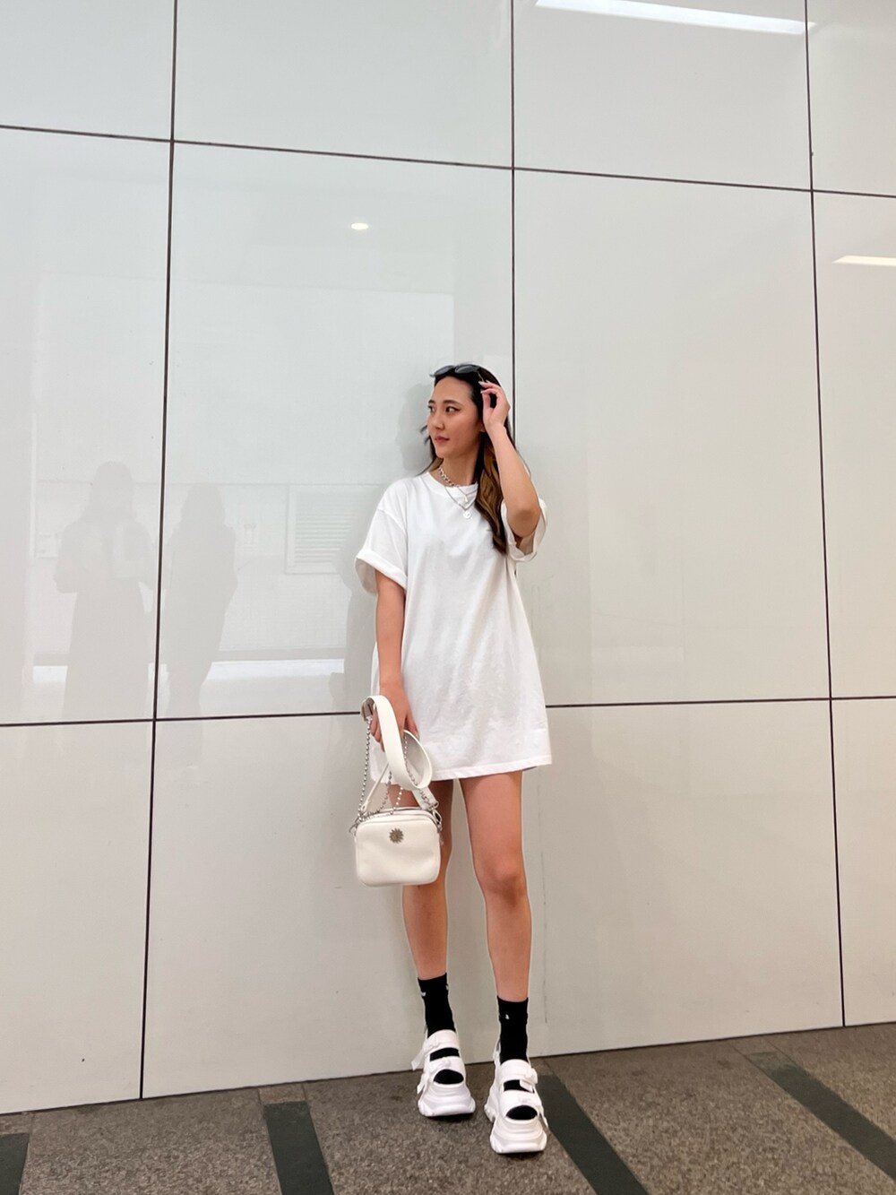 ホワイト系のTシャツ/カットソー、ホワイト系のサンダル、ホワイト系のショルダーバッグを着用したレディースの夏コーディネートの2枚目の写真