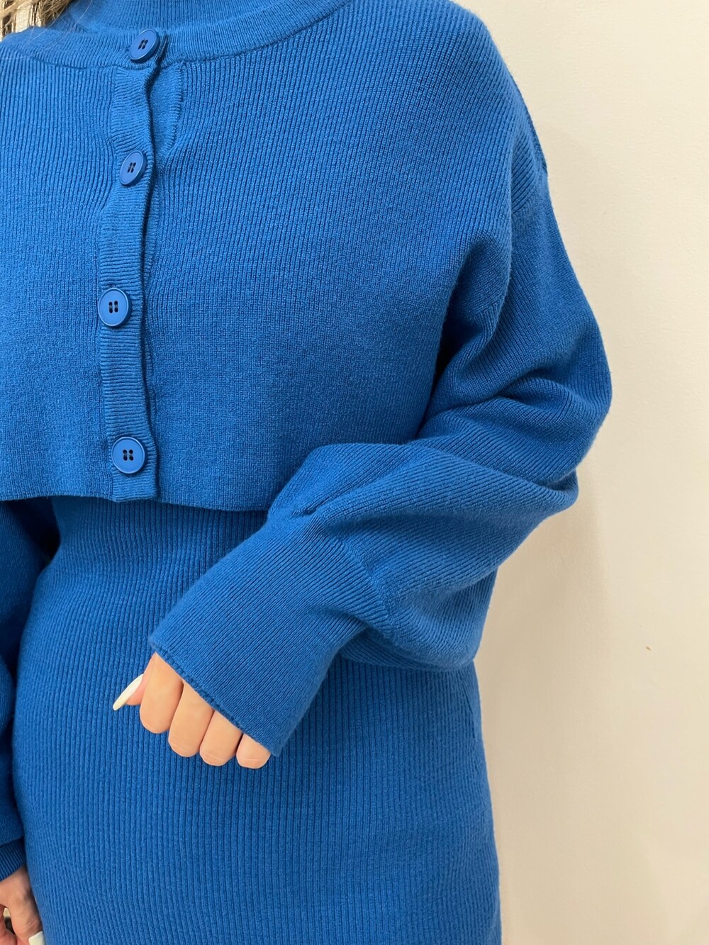 ブラック系のショルダーバッグ、ブルー系のワンピース、ホワイト系のブーツを着用したレディースの秋コーディネートの5枚目の写真