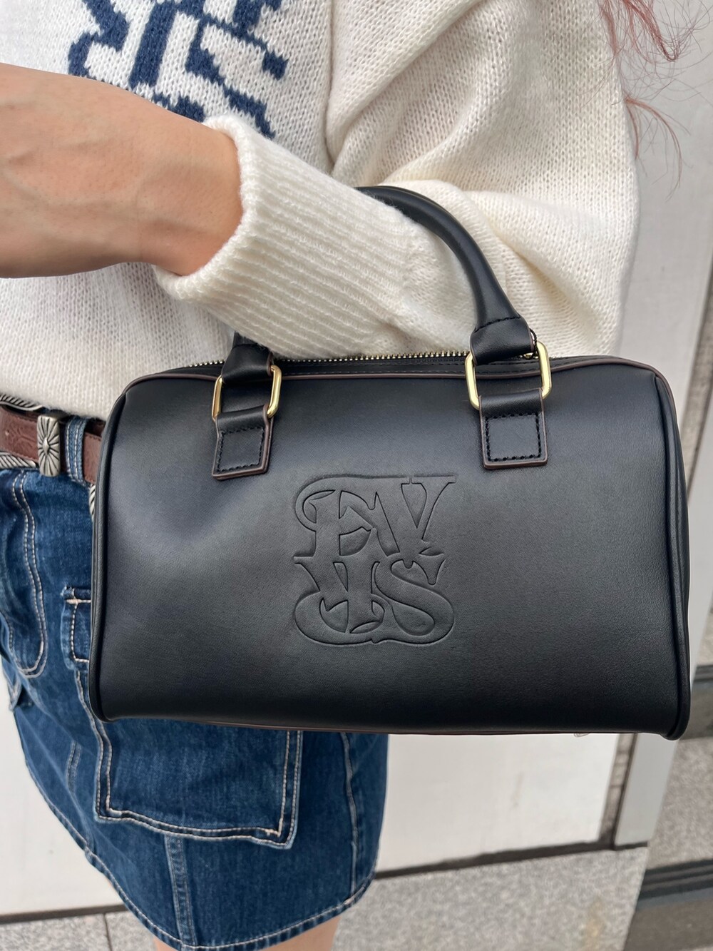 ホワイト系のニット/セーター、ブルー系のデニムスカート、ブラック系のボストンバッグを着用したレディースの冬コーディネートの7枚目の写真