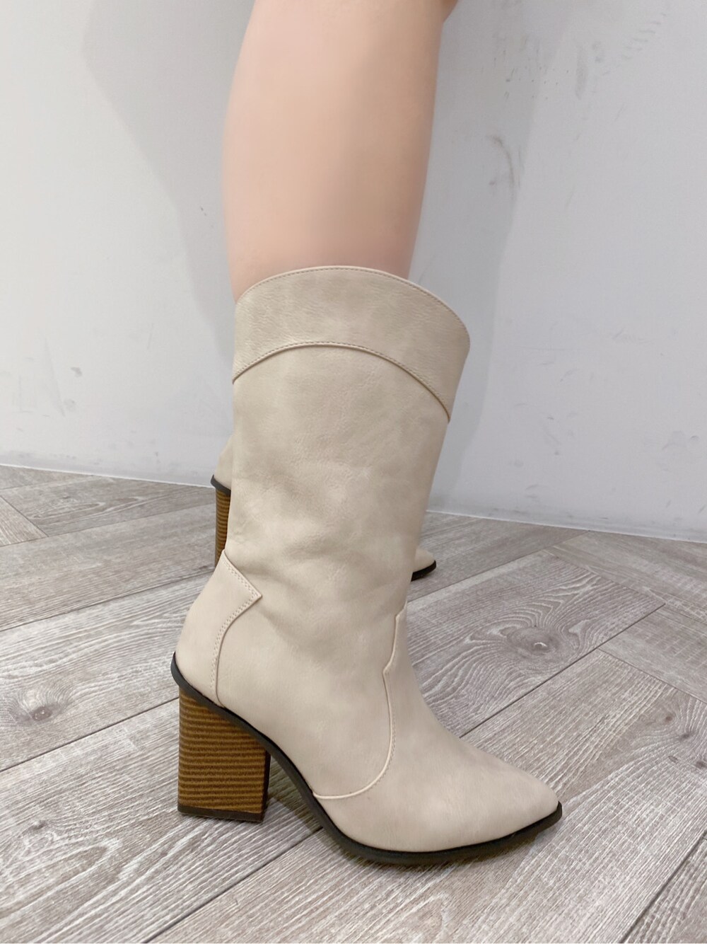 ベージュ系のブーツ、ホワイト系のワンピース、シルバー系のネックレスを着用したレディースの冬コーディネートの3枚目の写真