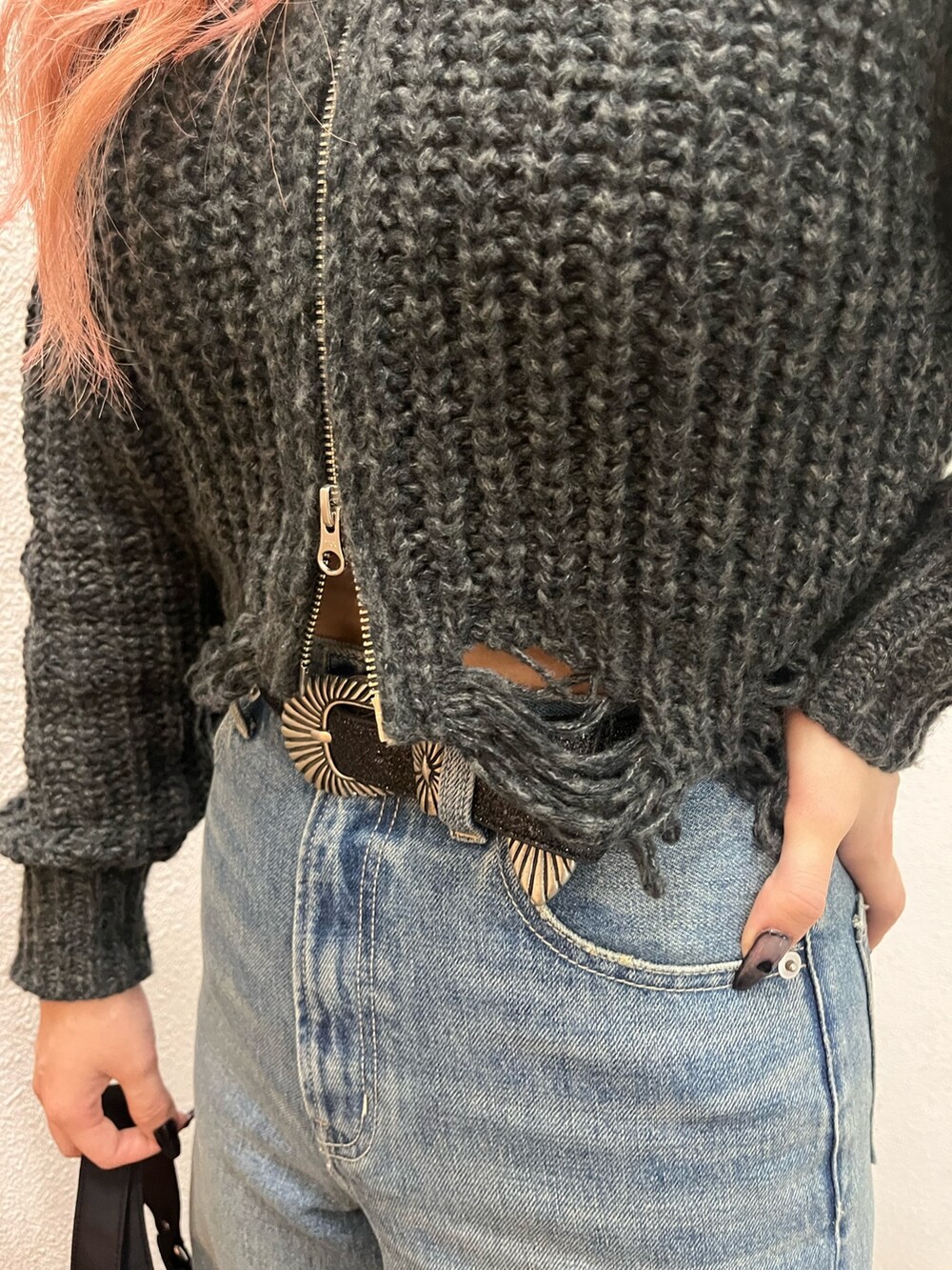 ブルー系のデニムパンツ、ブラック系のハンドバッグ、ブラック系のブーツを着用したレディースの冬コーディネートの6枚目の写真