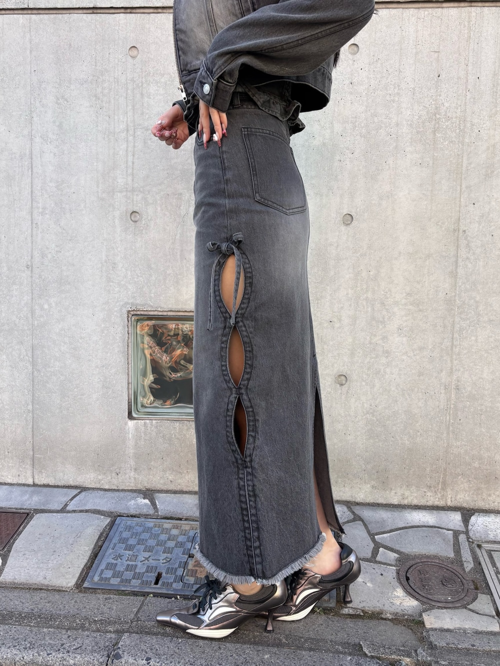 ブラック系のデニムジャケット、ブラック系のチューブトップ、ブラック系のデニムスカートを着用したレディースの冬コーディネートの3枚目の写真