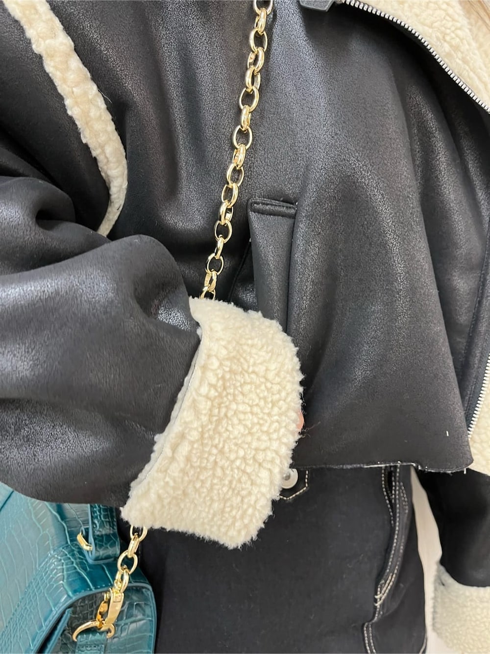 ブラック系のデニムスカート、ブラック系のブルゾン、ブラック系のブーツを着用したレディースの秋コーディネートの5枚目の写真