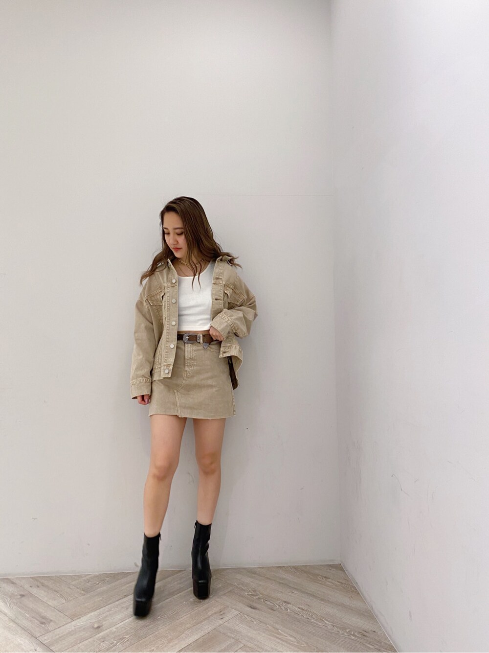 ベージュ系のデニムスカート、ベージュ系のデニムジャケット、ホワイト系のTシャツ/カットソーを着用したレディースの春コーディネートの2枚目の写真