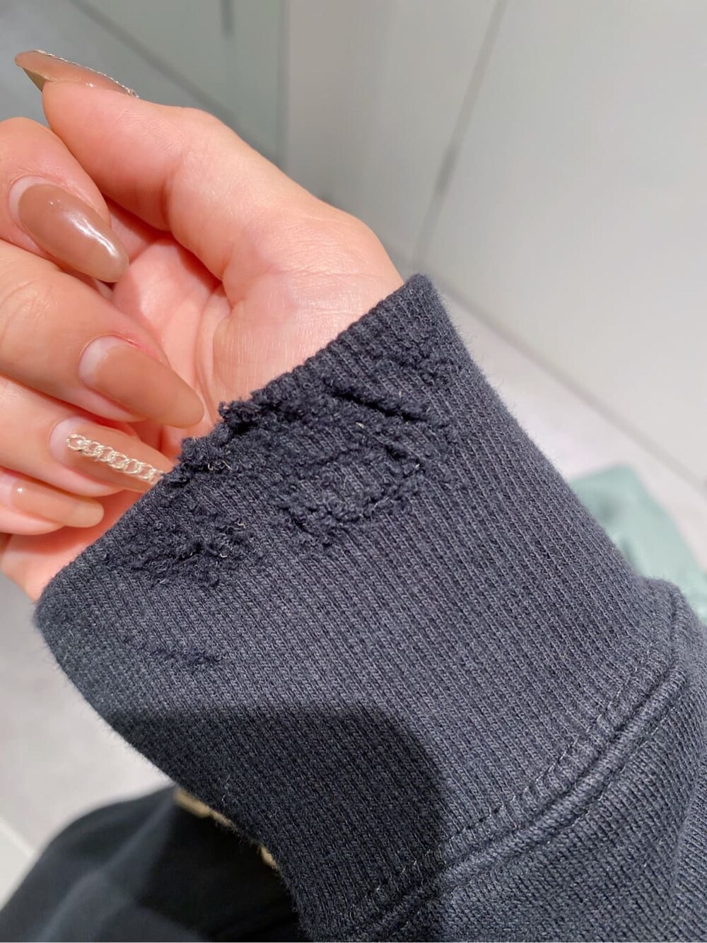 ブラウン系のデニムパンツ、ブラック系のパーカー、グリーン系のショルダーバッグを着用したレディースの秋コーディネートの4枚目の写真