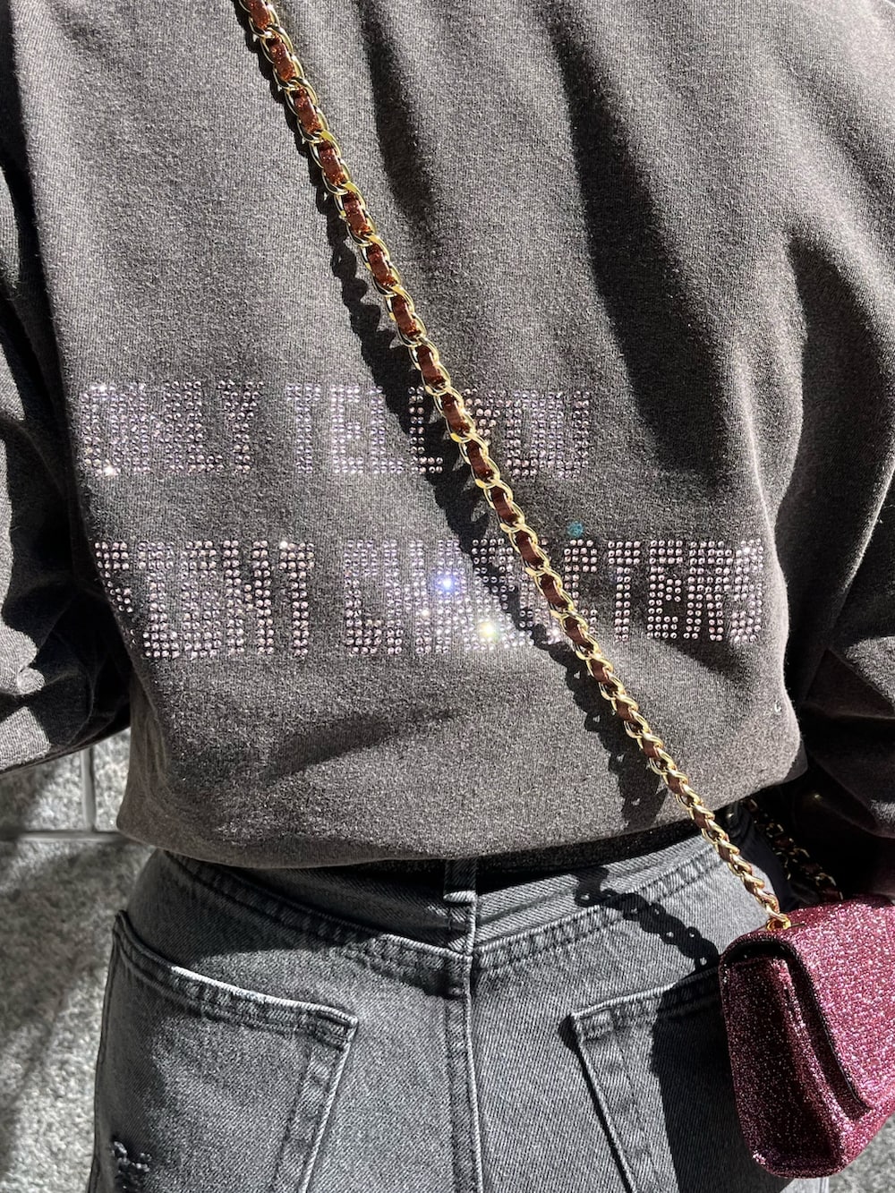 グレー系のTシャツ/カットソー、ブラック系のデニムパンツ、ピンク系のショルダーバッグを着用したレディースの冬コーディネートの4枚目の写真