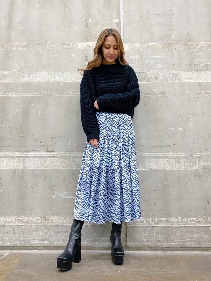 ブラック系のブーツ、ブルー系のワンピース、ホワイト系のブルゾンを着用したレディースの冬コーディネートの3枚目の写真