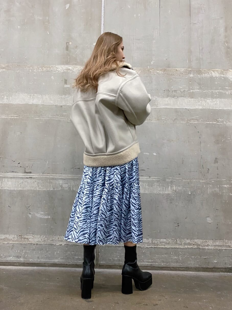 ブラック系のブーツ、ブルー系のワンピース、ホワイト系のブルゾンを着用したレディースの冬コーディネートの2枚目の写真