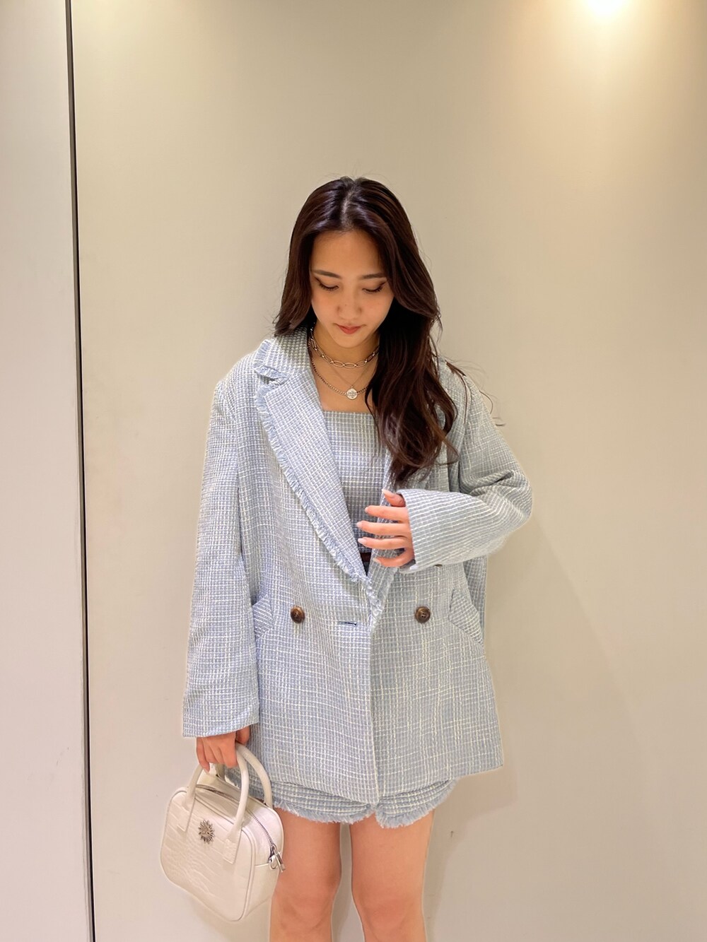 ブルー系のテーラードジャケット、ブルー系のキャミソール、ブルー系のスカートを着用したレディースの冬コーディネートの2枚目の写真