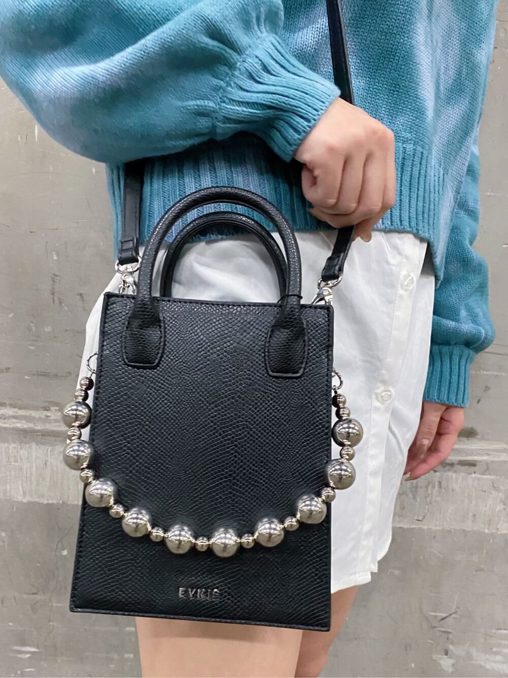 ブラック系のブーツ、ブルー系のニット/セーター、ホワイト系のシャツ/ブラウスを着用したレディースの秋コーディネートの6枚目の写真