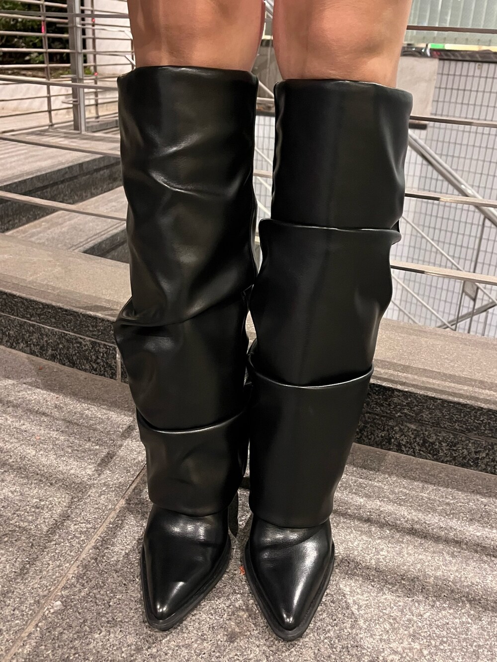 ブラック系のスウェット、ピンク系のショルダーバッグ、ブラック系のブーツを着用したレディースの冬コーディネートの8枚目の写真