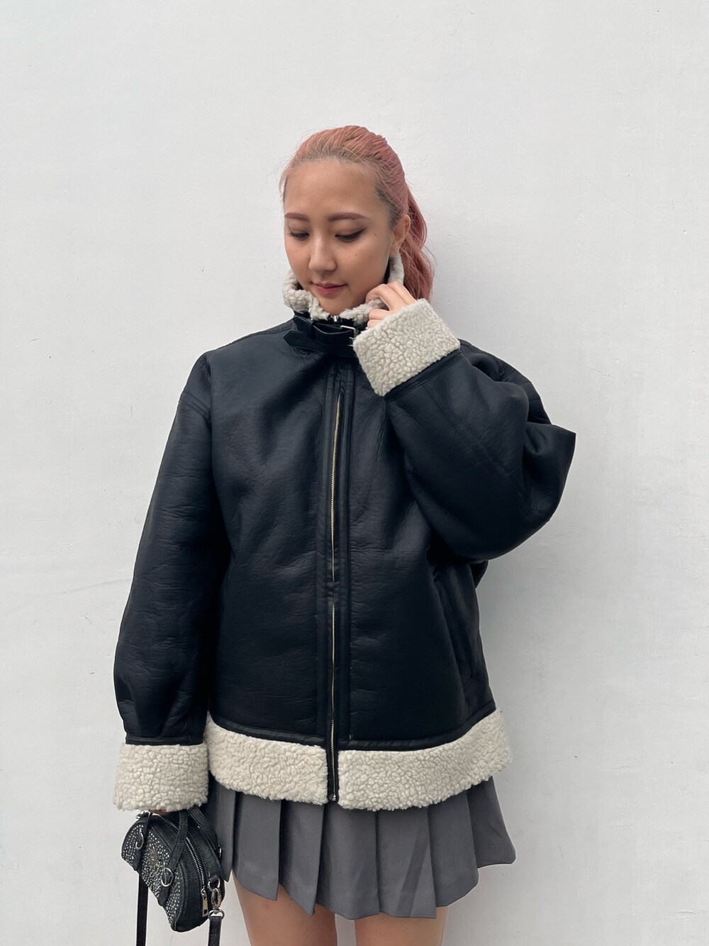 ブルー系のスウェット、グレー系のスカート、ブラック系のハンドバッグを着用したレディースの冬コーディネートの3枚目の写真