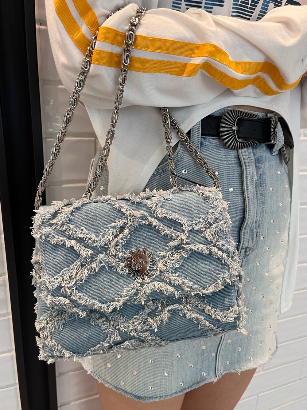 ホワイト系のTシャツ/カットソー、ブルー系のデニムスカート、ブルー系のショルダーバッグを着用したレディースの春コーディネートの7枚目の写真