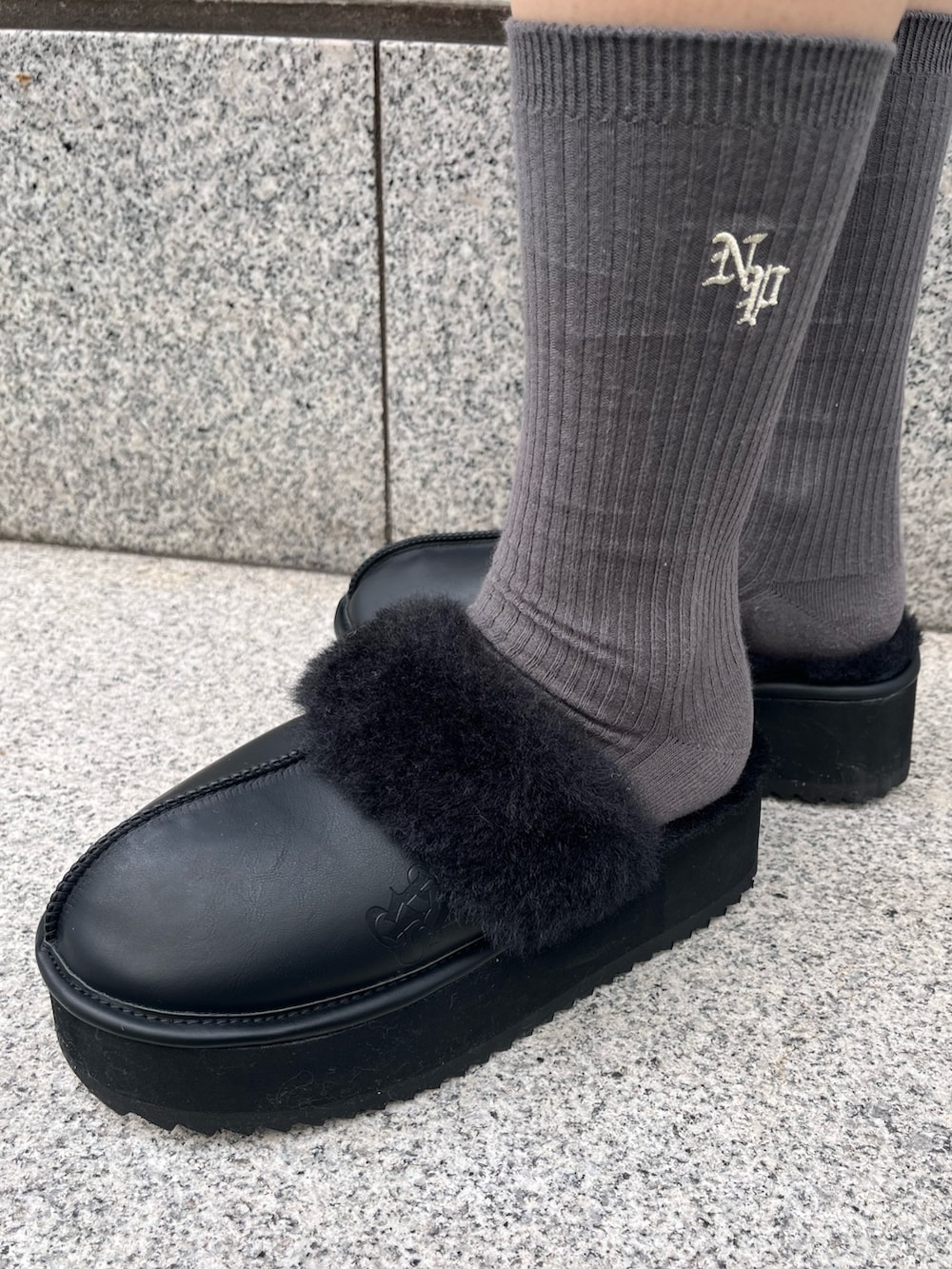 ブルー系のスウェット、グレー系のスカート、ブラック系のハンドバッグを着用したレディースの冬コーディネートの9枚目の写真