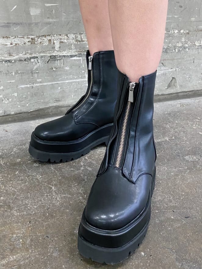 ブラック系のトレンチコート、グリーン系のボストンバッグ、ブラック系のブーツを着用したレディースの冬コーディネートの8枚目の写真