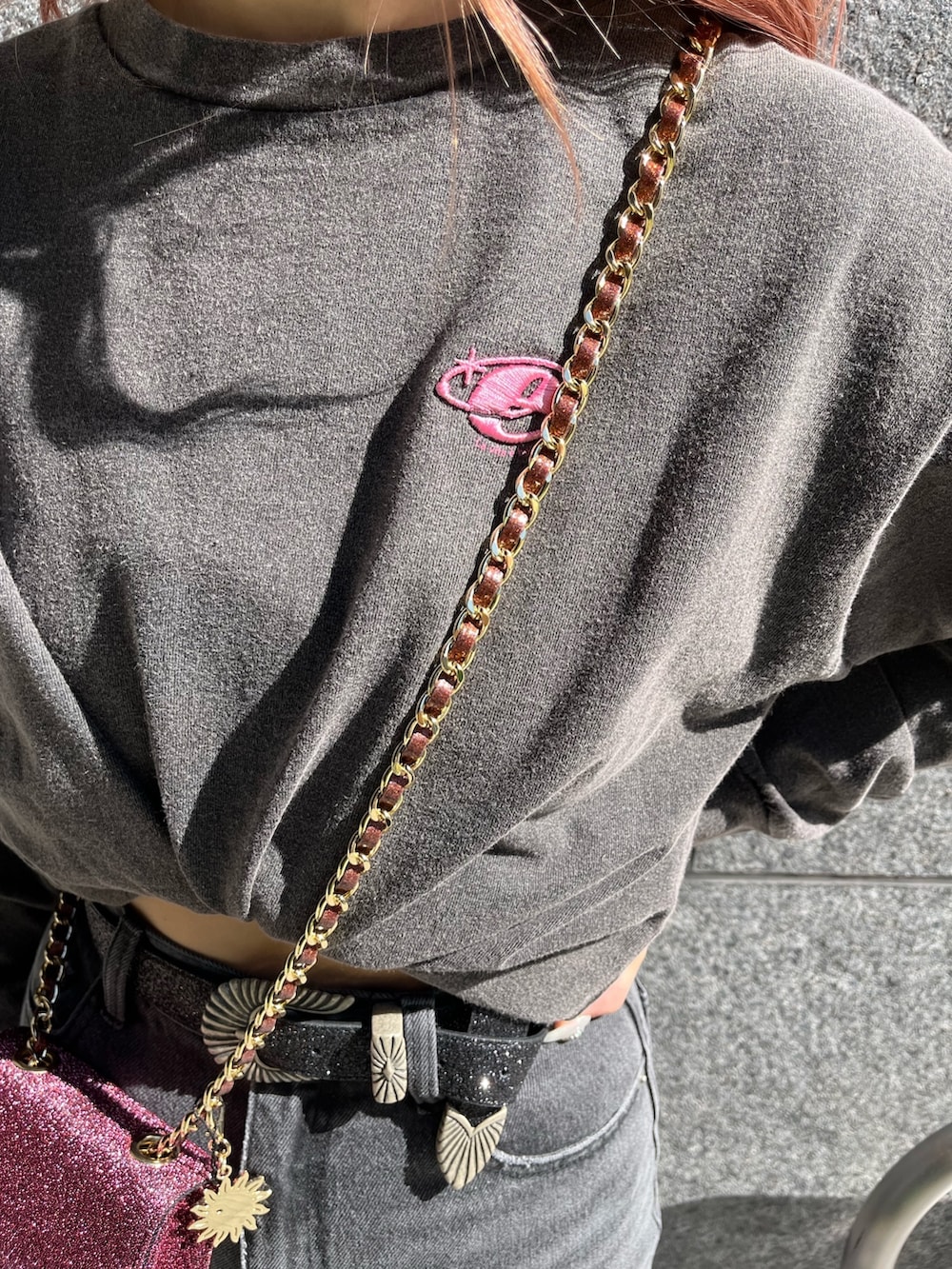 グレー系のTシャツ/カットソー、ブラック系のデニムパンツ、ピンク系のショルダーバッグを着用したレディースの冬コーディネートの3枚目の写真