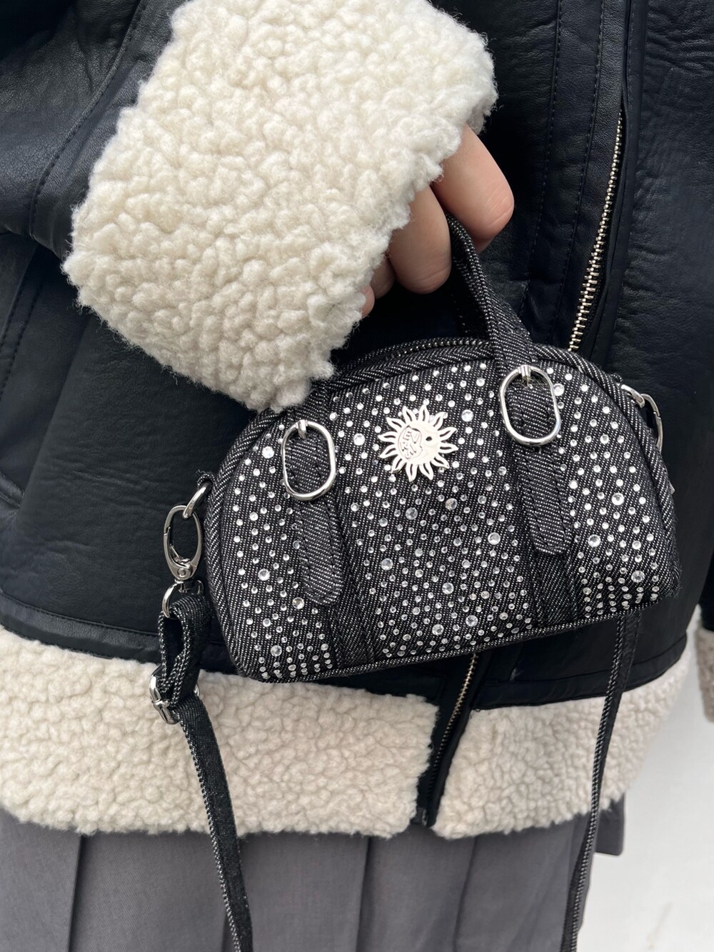 ブルー系のスウェット、グレー系のスカート、ブラック系のハンドバッグを着用したレディースの冬コーディネートの7枚目の写真