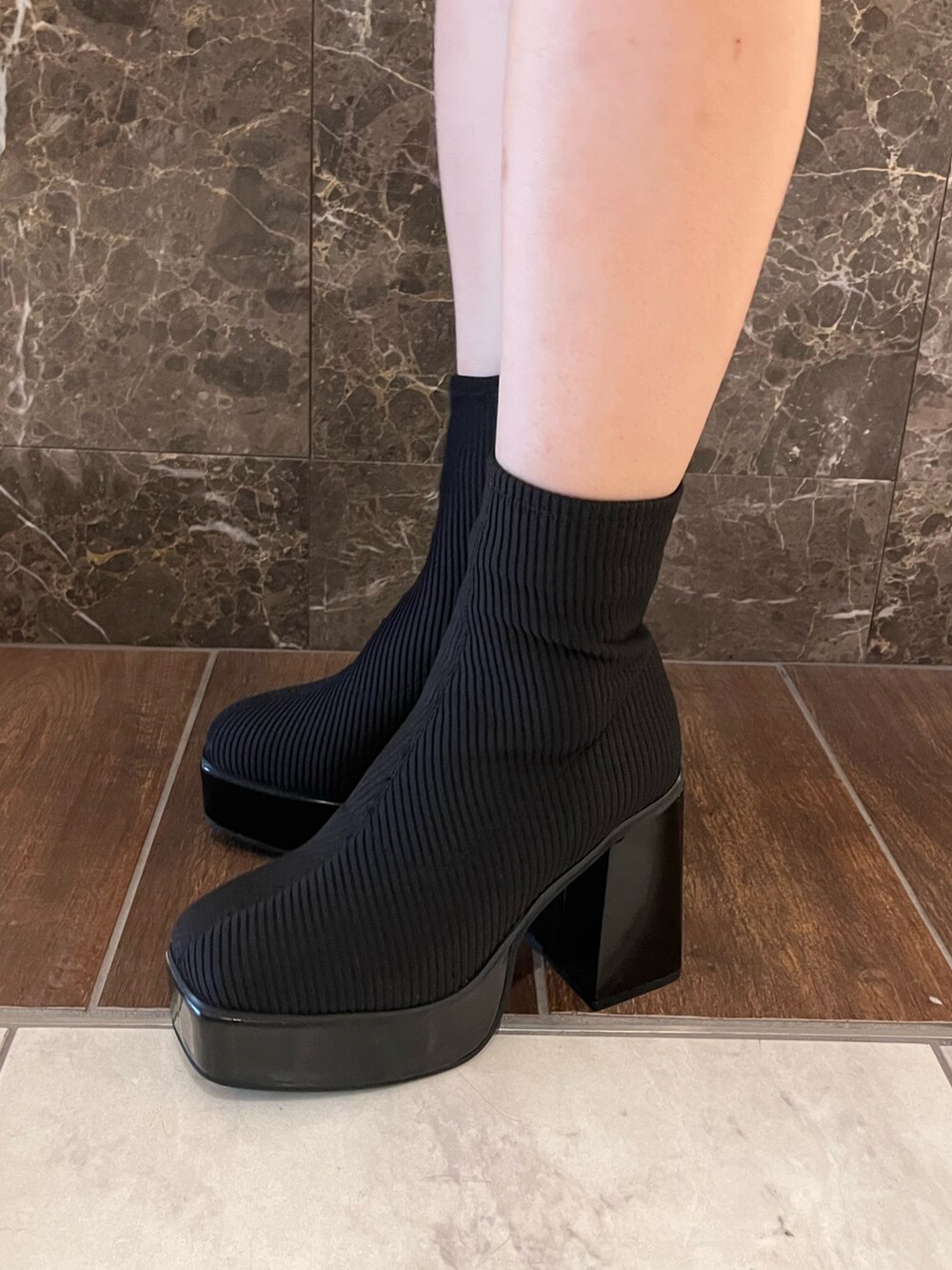 ブラック系のニット/セーター、シルバー系のスカート、その他のブーツを着用したレディースの秋コーディネートの4枚目の写真