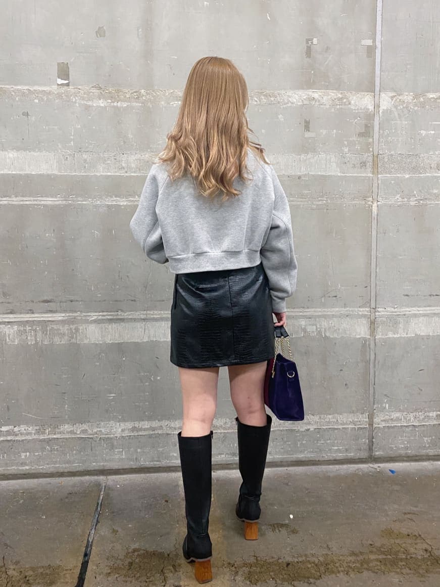 ブラック系のブーツ、グレー系のスウェット、ブラック系のスカートを着用したレディースの冬コーディネートの2枚目の写真