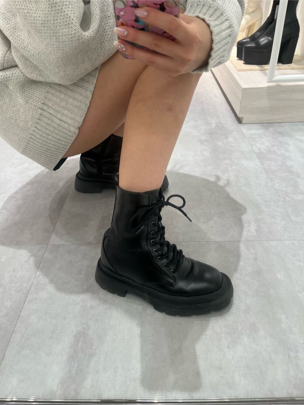 ブラック系のブーツ、ブラック系のその他パンツ、グレー系のニット/セーターを着用したレディースの夏コーディネートの6枚目の写真